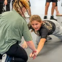 Female student drilling a takedown entry with a training partner